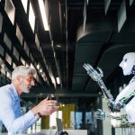 Hombre interactuando con un robot en un entorno industrial.